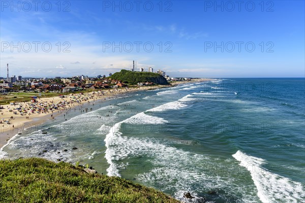 Crowded beach and the city on a beautiful sunny day in the summer of Torres city on the coast of Rio Grande do Sul state