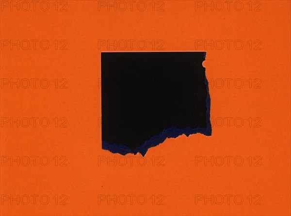 Torn orange paper with black hole