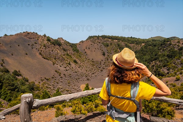 A young tourist with a hat at the viewpoint of the Fireba volcano in La Llania park in El Hierro