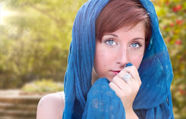 Pretty blue eyed young red haired adult female outdoor portrait