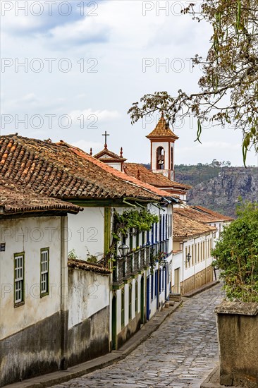 Cobbled street in the city of Diamantina with its colonial-style houses and colorful balconies with the church bell tower in the background