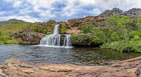 Cascade and lake with mountains in background on Biribiri environmental reserve on Diamantina