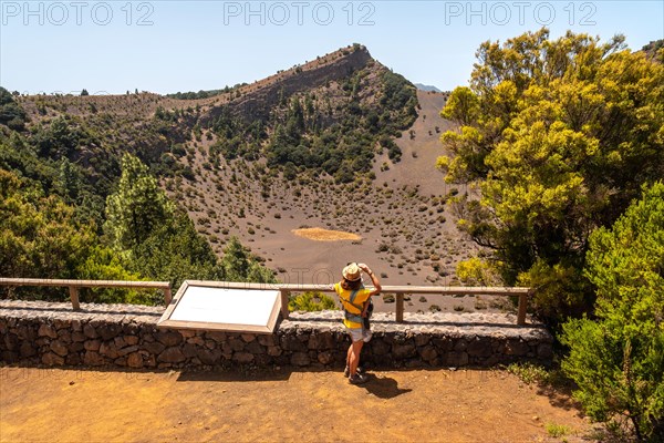 A young woman at the viewpoint of the Fireba volcano in La Llania park in El Hierro