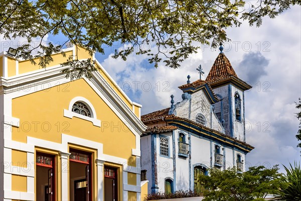 Historic baroque church next to a neoclassical building lit by the afternoon sun in the city of Diamantina in Minas Gerais