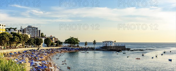 Sunny Sunday in the summer of the city of Salvador in Bahia with Barra beach full of people during sunset