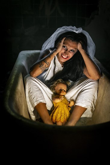 Deranged bride with a doll in a bathtub. Inspired by the traditional American legend of la llorona