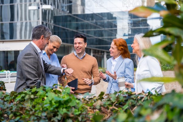 Chatting next to a green area. Group executives or businessmen and businesswoman in a business area