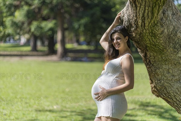 Portrait of pregnant latina woman in a park