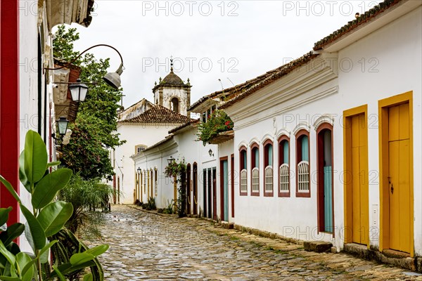 Cobblestone street in the historic center of Paraty with old church in the background