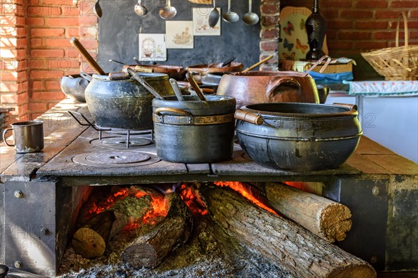 Traditional Brazilian food being prepared in clay pots and in the old and popular wood stove