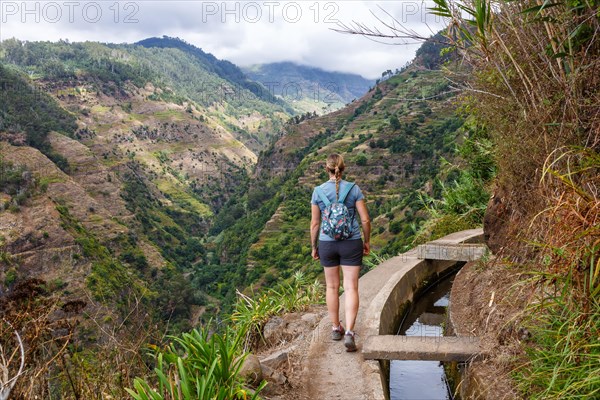 Young woman hiking along the Levada Nova hiking trail on Madeira Island