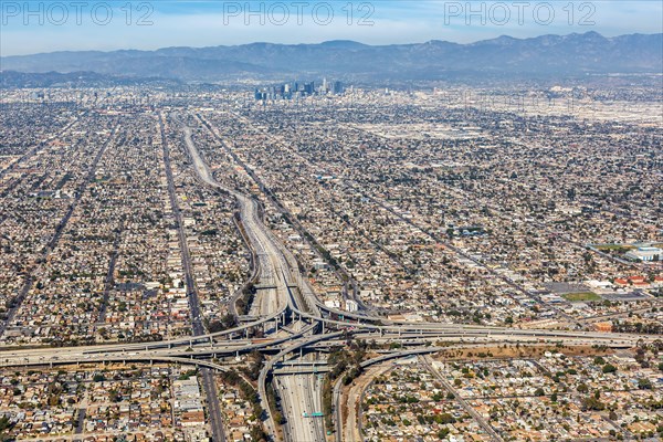 Aerial view of Harbor interchange and Century Freeway traffic with downtown Los Angeles