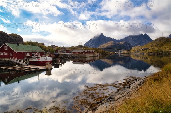 Rorbuer and high mountains reflected in a fjord