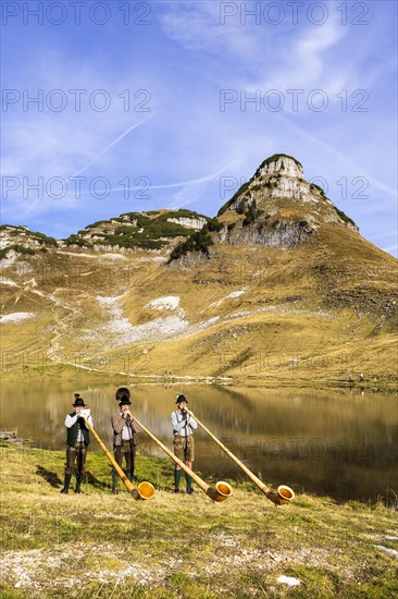 The Austrian alphorn trio Klangholz plays the alphorn at the Augstsee on Mount Loser