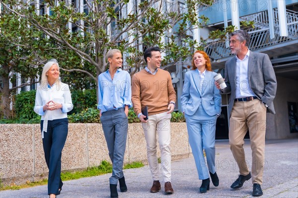 Group of coworkers walking outdoors in a corporate office area