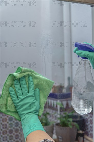 Hands of a woman with green gloves