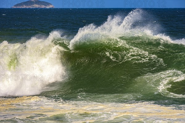 Big wave breaking at Ipanema beach in Rio de Janeiro on a sunny day and strong winds