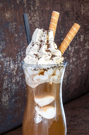 Ice cream cafe with cream in glass on brown background