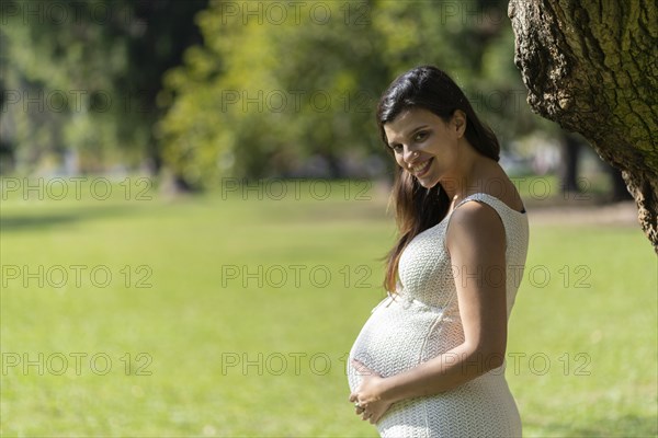 Portrait of pregnant latina woman in a park