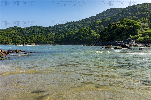 Paradise tropical beach with mountains and forests around in coastal Bertioga of Sao Paulo state