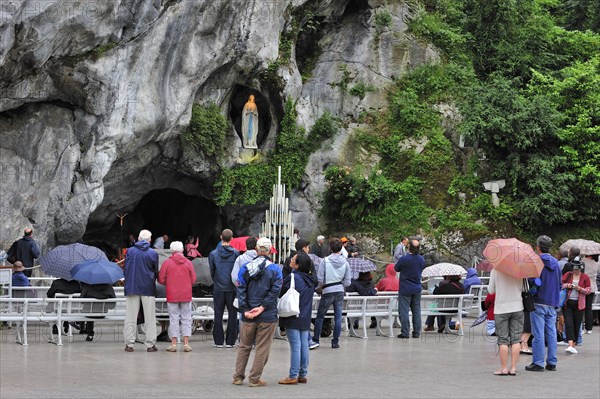 Pilgrims praying in front of the grotto at the Sanctuary of Our Lady of Lourdes