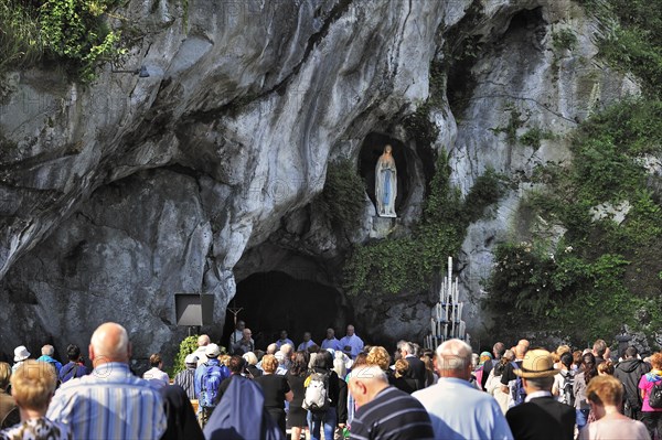 Pilgrims praying in front of the grotto at the Sanctuary of Our Lady of Lourdes