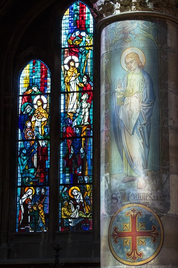 Decorated pillar and colourful stained glass windows in the eglise Sainte-Segolene