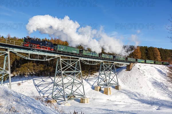 Steam train of the Fichtelbergbahn railway Steam locomotive on a bridge in winter in Oberwiesenthal