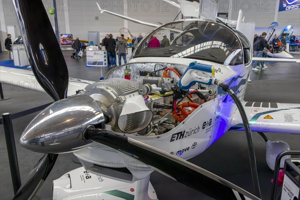 The front part of the electric aircraft with a propeller without a canopy and an electric motor with a battery charging cable