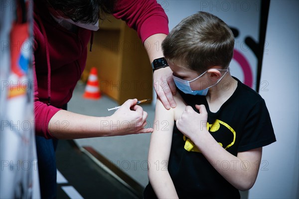 A boy is vaccinated by a doctor with the BioNTech Pfizer children's vaccine at a COVID-19 vaccination and testing centre at Autohaus Olsen in Iserlohn