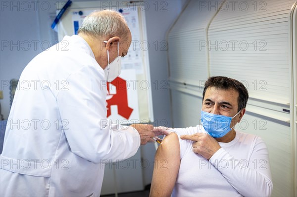 A pharmacist vaccinates a man with the Comirnaty BioNTech vaccine against the coronavirus in a pharmacy in Duesseldorf