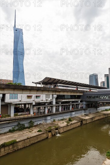 Metro train of the LRT Kelana Jaya Line at the Pasar Seni stop and skyscraper Merdeka PNB 118 Tower in Kuala Lumpur