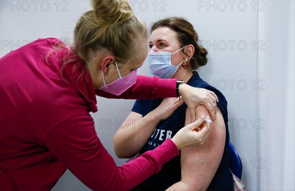 A woman is vaccinated by a doctor with the BioNTech Pfizer vaccine at a COVID-19 vaccination and testing centre at Autohaus Olsen in Iserlohn