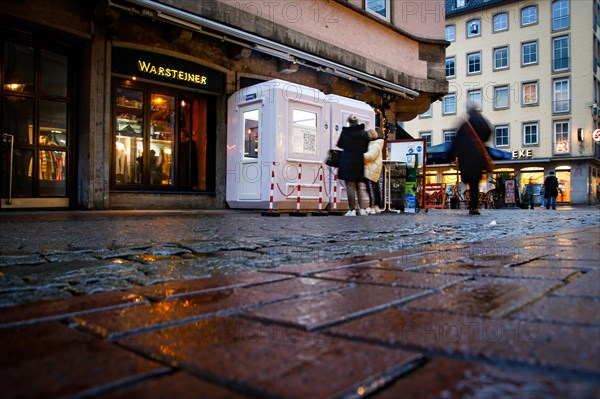 Two people wait for their test appointment in front of a COVID-19 test centre in Duesseldorf