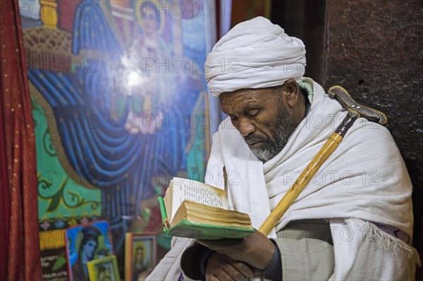 Priest reading the bible at Biete Medhane Alem