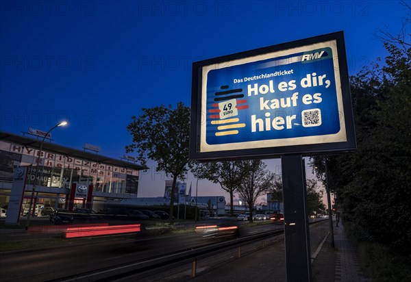 Advertising poster for the Deutschlandticket on a busy motorway