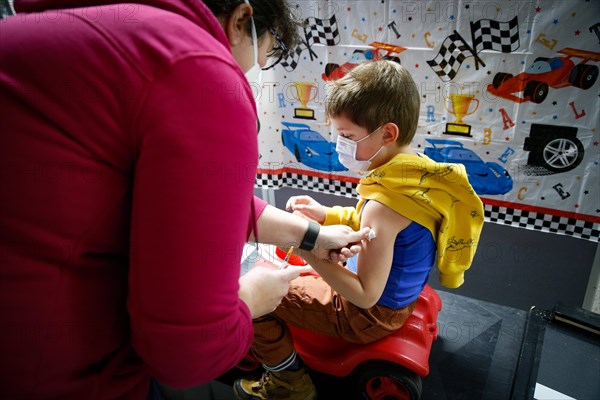 A boy is vaccinated by a doctor with the BioNTech Pfizer children's vaccine at a COVID-19 vaccination and testing centre at Autohaus Olsen in Iserlohn