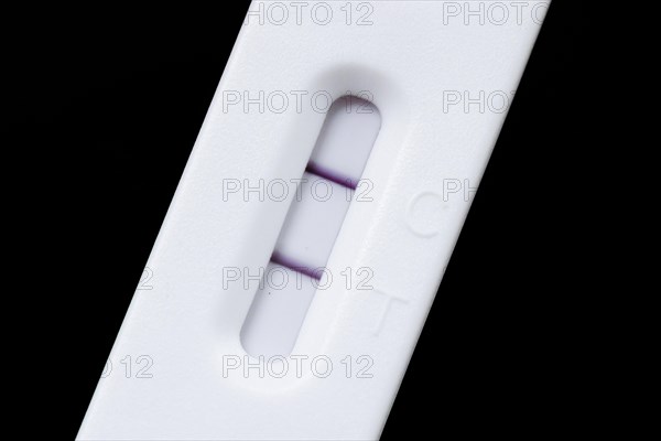 A positive SARS-CoV-2 Rapid Ag Antigen rapid test lies on a table. Berlin