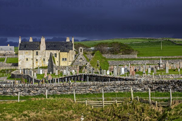 Black storm clouds rolling in over ruined church and the Balnakeil House