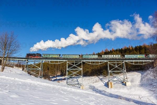 Steam train of the Fichtelbergbahn railway Steam locomotive on a bridge in winter in Oberwiesenthal