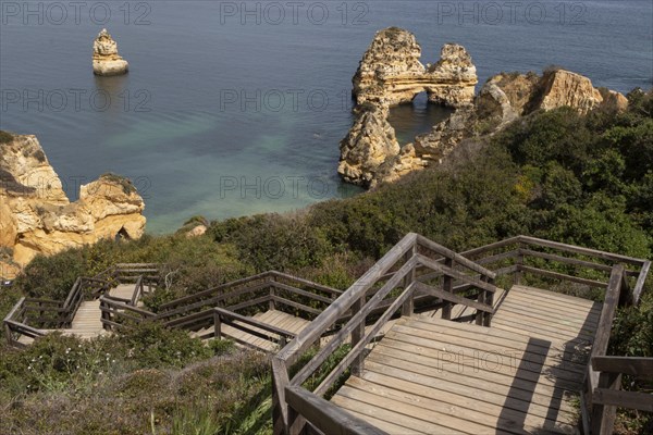 Wooden stairs and rock formation at Praia do Camilo on the coast of Lagos