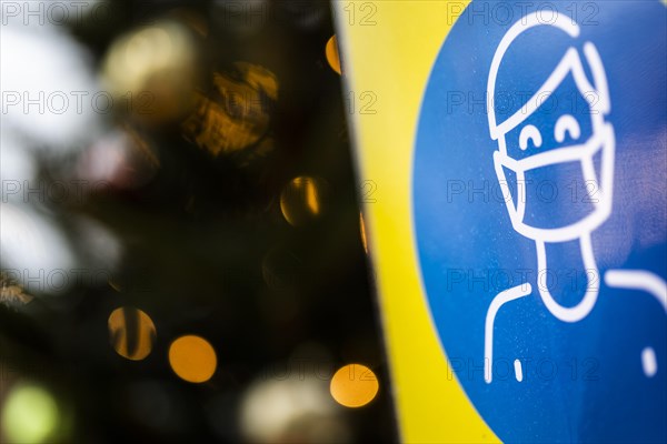 A sign indicating that masks are compulsory stands out at the Christmas market on Alexanderplatz in Berlin