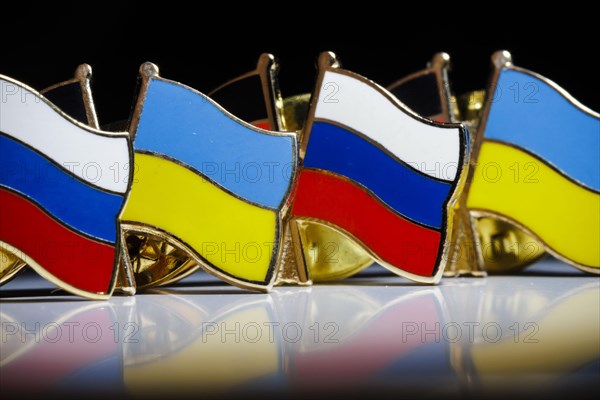 Symbolic photo on the topic ' Diplomacy between Russia and Ukraine '. Pins with the national flags of Russia and Ukraine stand on a table. Berlin