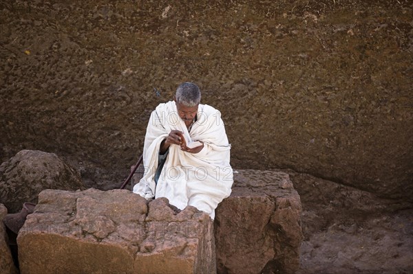 Man in white reading the bible at Biete Medhane Alem