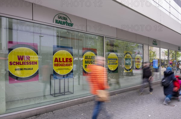 People walk in front of shop windows of a Galeria Kaufhof store
