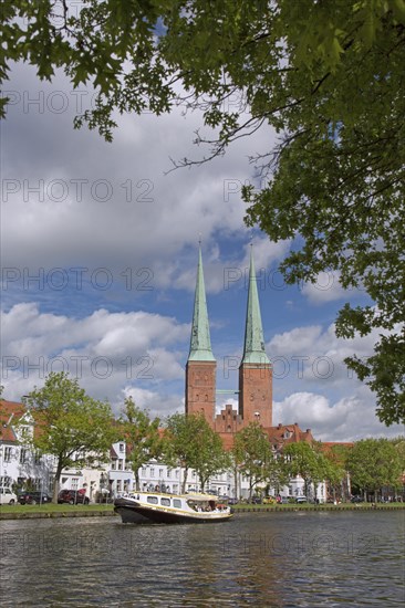 Tourist boat on the river Trave and the Luebeck Cathedral