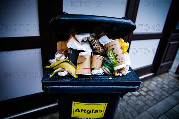 Disposable cardboard cups lie in an overfilled dustbin in Duesseldorf