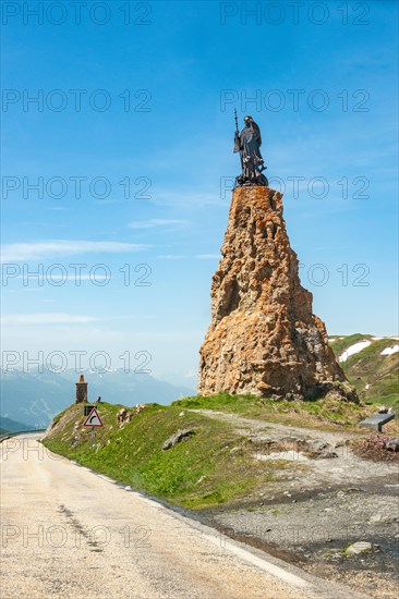 Satue of monk of Cistercian Order Bernard de Clairvaux Bernard of Clairvaux on rock pillar on top of pass of Alpine pass road Little Saint Bernard in Graian Alps