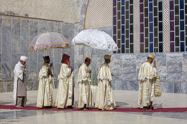 Orthodox priests with parasols during ceremony walking around the Church of Our Lady Mary of Zion