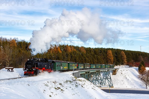 Steam train of the Fichtelbergbahn railway Steam locomotive on a bridge in winter in Oberwiesenthal